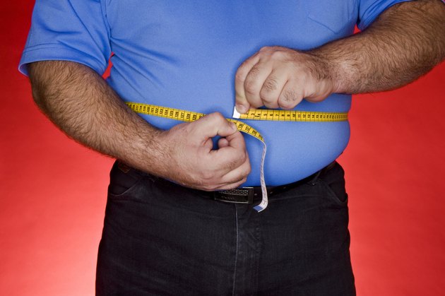 Obese man measuring waist