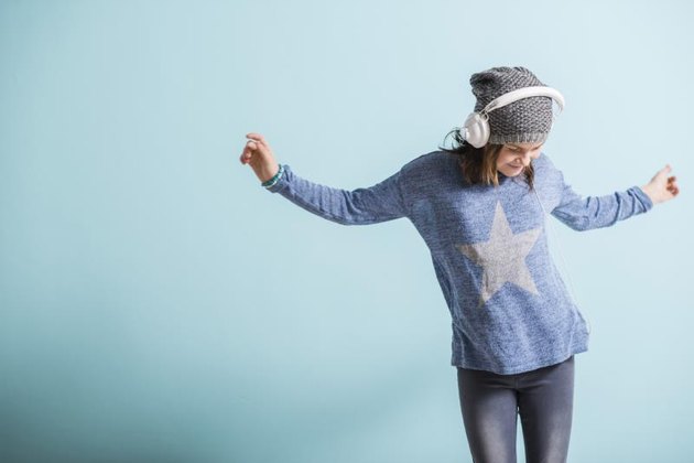 Girl with head phones dancing and listening to music