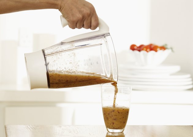 Woman pouring smoothie into glass, close up