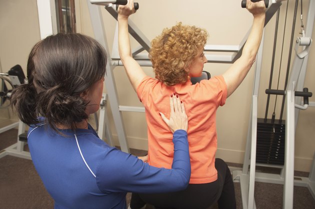 Personal trainer helping woman
