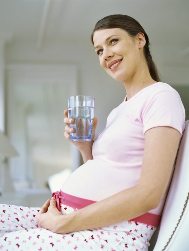 low angle view of a pregnant woman holding a glass of water