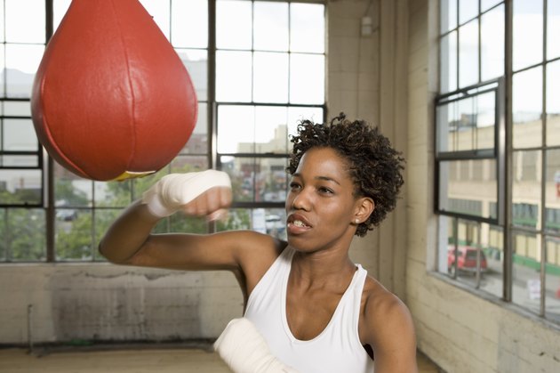 Woman exercising with punching bag in gym