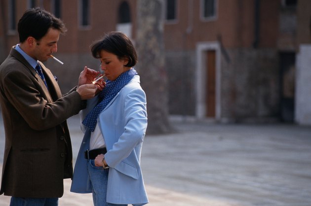 Man lighting woman's cigarette in street