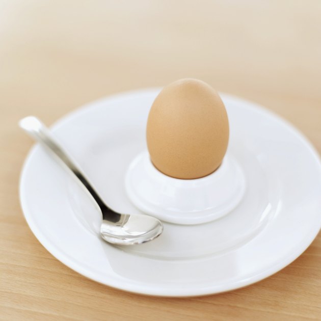 egg in an egg holder on a plate with a spoon