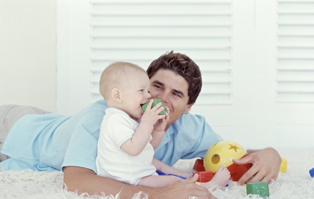 Father playing with baby (6-12 months), indoors