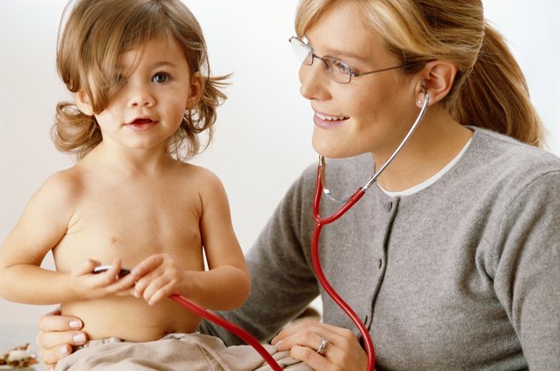 Girl (18-24 months) and doctor smiling
