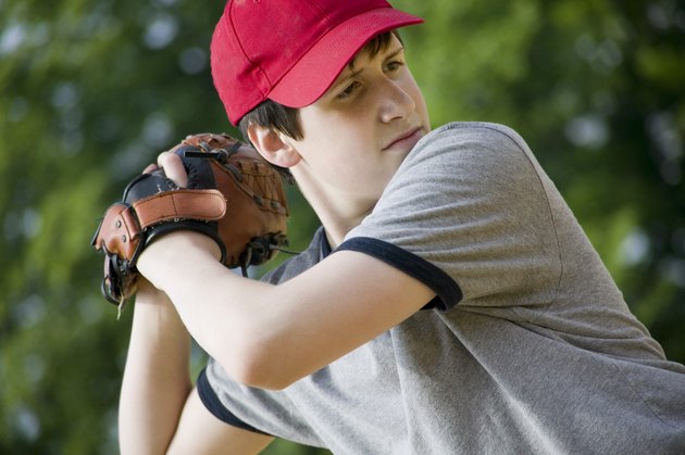 Teenage boy pitching baseball