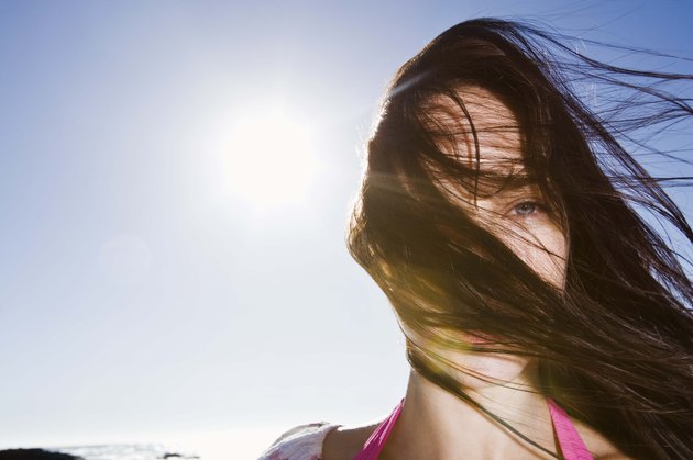 Woman with messy hair blowing on windy day