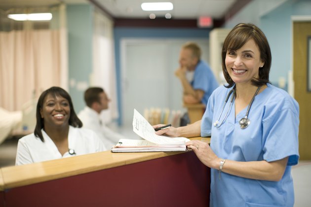 Female doctor with receptionist in hospital, smiling, portrait
