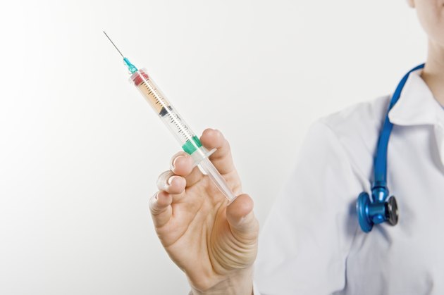 Doctor with syringe, mid section