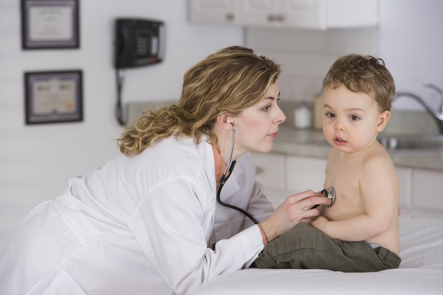 Doctor examining boy with stethoscope