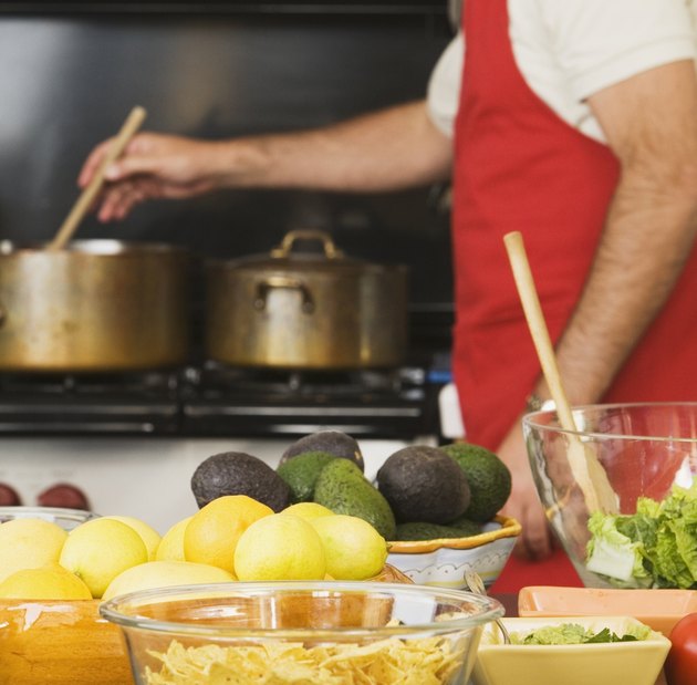 Food on counter in front of man cooking