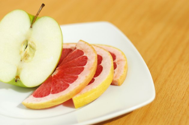 Close-up of an apple pie and slice of grapefruit in a plate