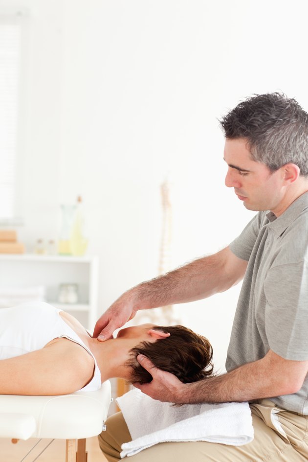 Chiropractor massaging a woman's neck