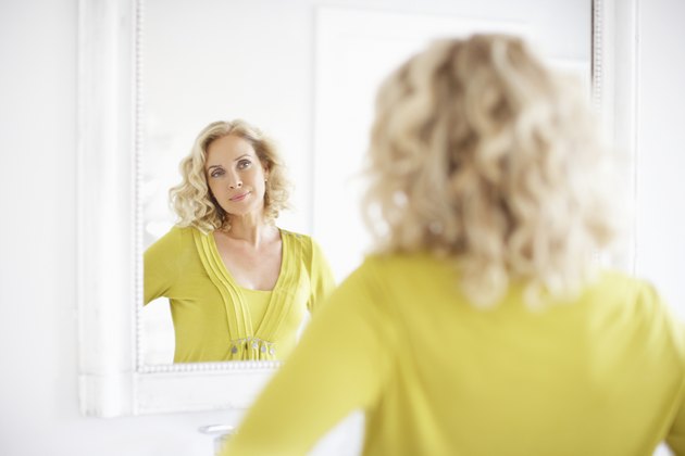 Mature woman looking in mirror