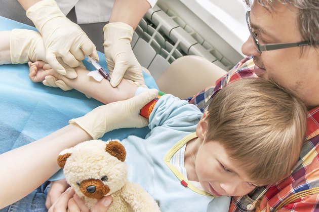 Collecting a blood from a vein from the kid.