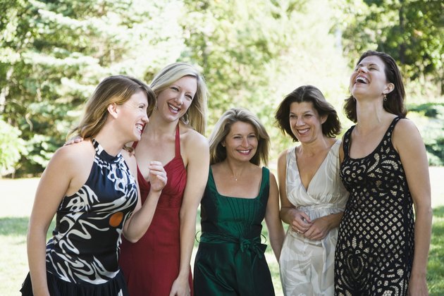 Five women standing in a garden and smiling