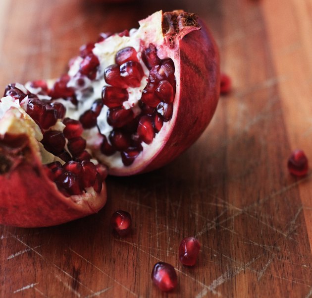 Freshly split pomegranate on a wooden chopping board