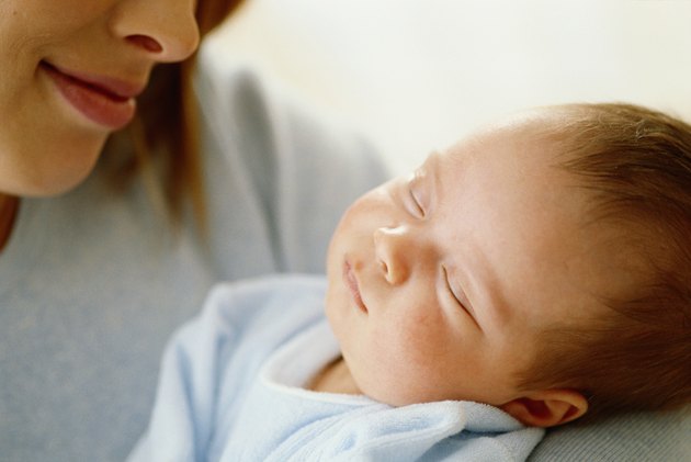 Woman looking down at baby sleeping