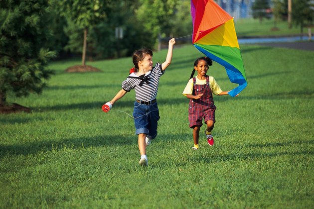 Kids running with rainbow kite
