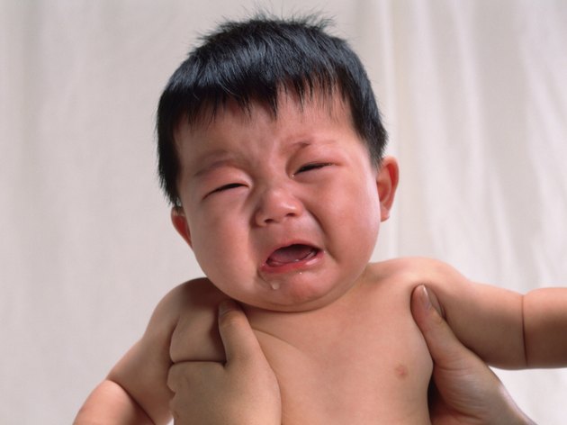 Baby boy is lifted, crying, portrait, front view