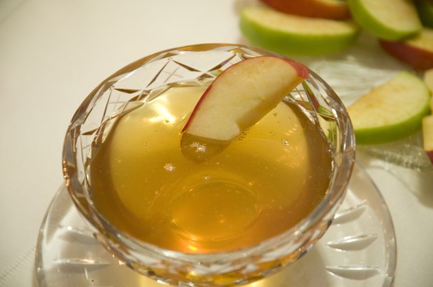 Apple slice in bowl of honey