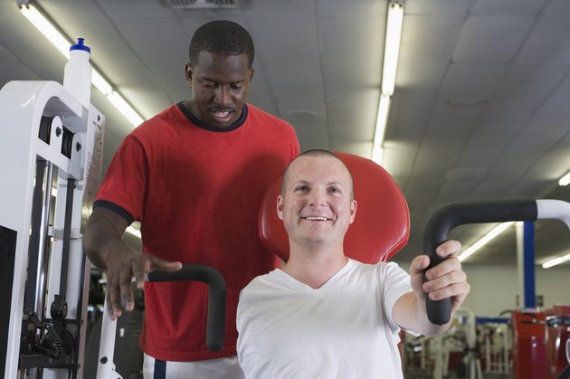 One-armed man in gym with trainer
