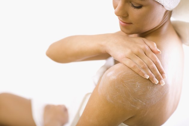 Young woman applying lotion