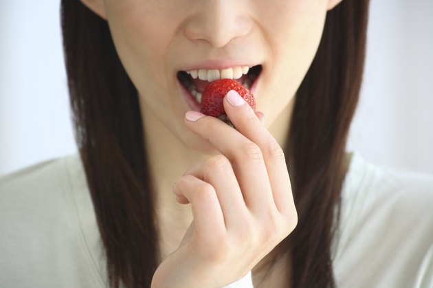 Close Up Image of a Woman Eating a Strawberry, Front View