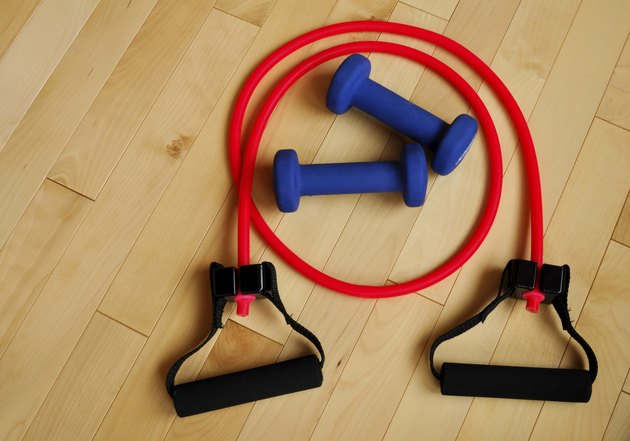 Red Resistance Band and Blue Weights on Gym Floor