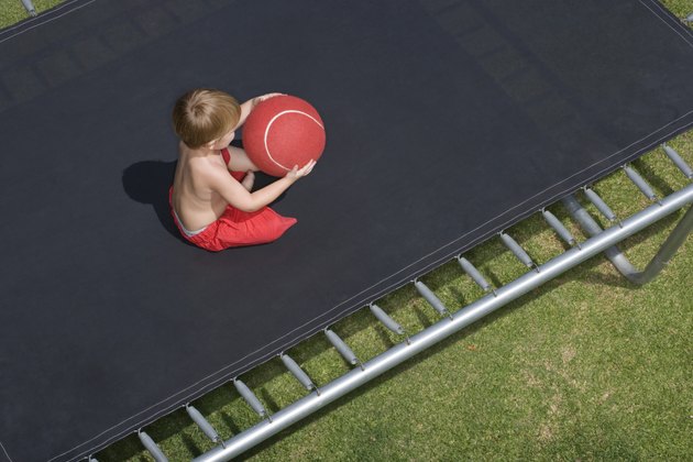 High angle view of boy with ball on trampoline