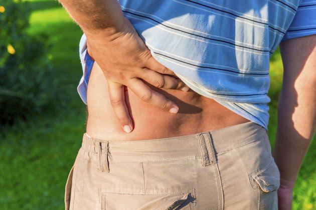 man holding his hand sore lower back