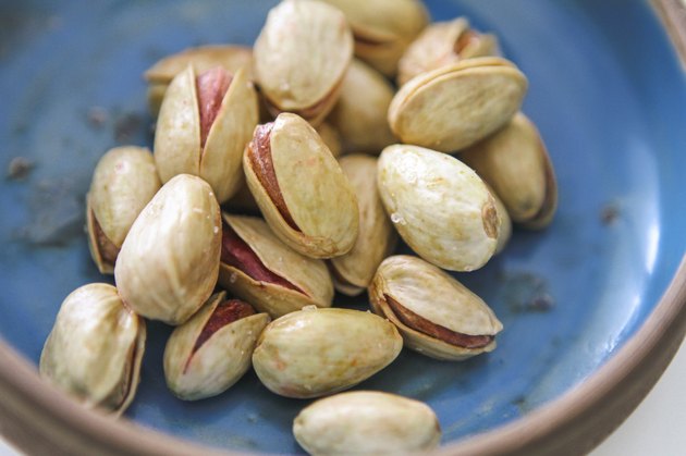 Lemon and safran roasted salted pistachios in a blue bowl