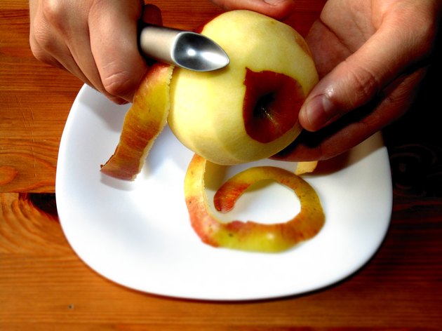 Hands peeling apple