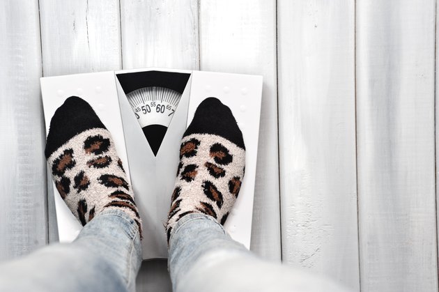Woman on weight scale in casual clothes