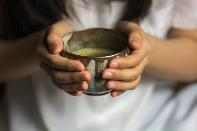Girl holding a Japanese tea cup