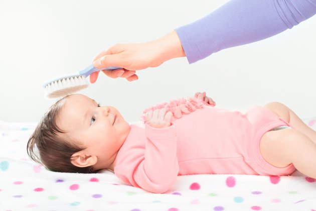 Mum brushing her little daughter hair
