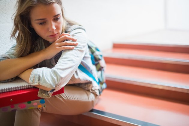 Sad lonely student sitting on stairs