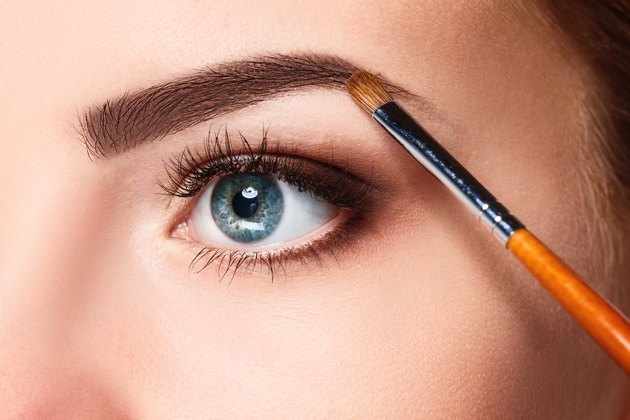Beautiful female eyes with make-up and brush