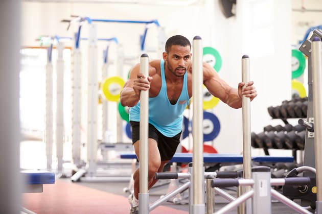 Muscular man working out using equipment at a gym