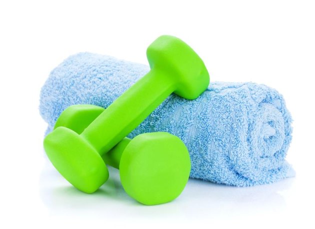 Two green dumbells and towel. Isolated on white background