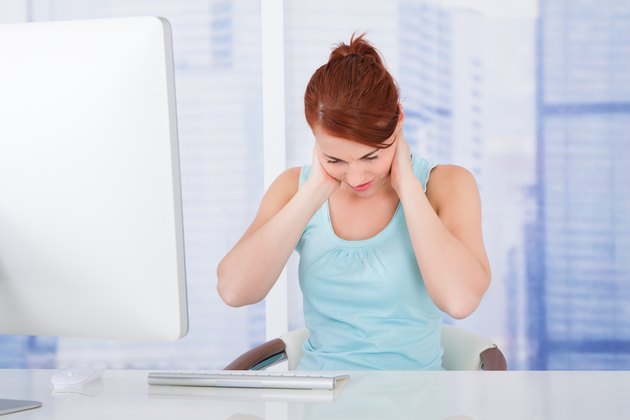 Businesswoman Suffering From Neckache At Computer Desk