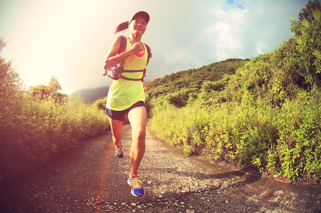 young fitness woman runner running on mountain trail