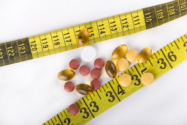 Diet Pills with yellow measuring tape