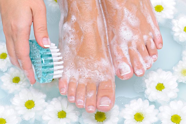 Woman washes and cleans her foot