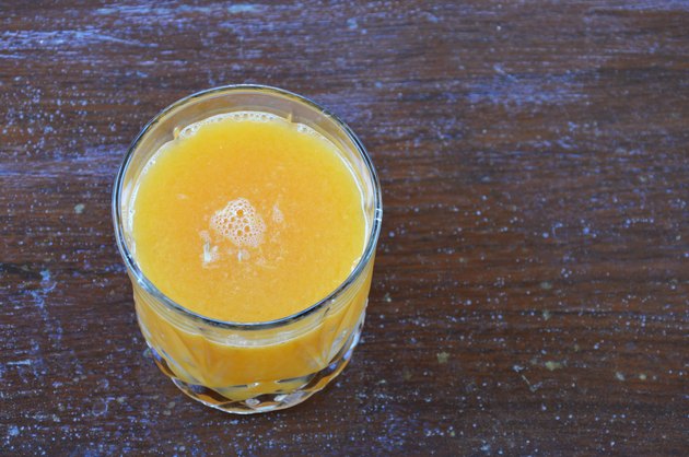 glass of orange juice on wooden table