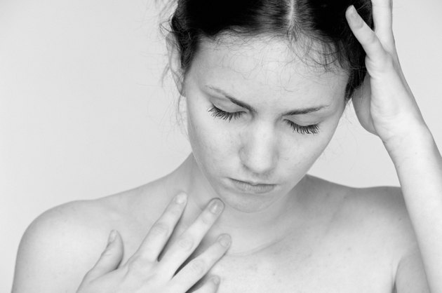 Young woman with bare shoulders in deep reflective thought.