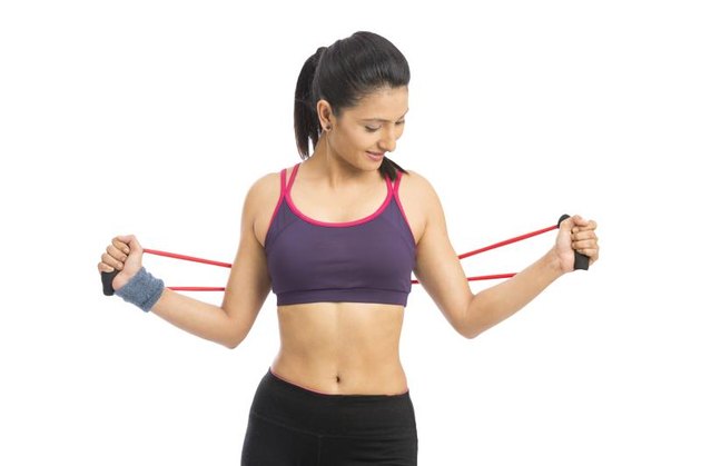 young fit women working out with rubber band over white background