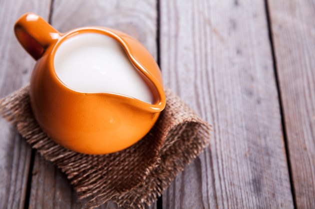 healthy drink. orange clay jug with milk in rustic style
