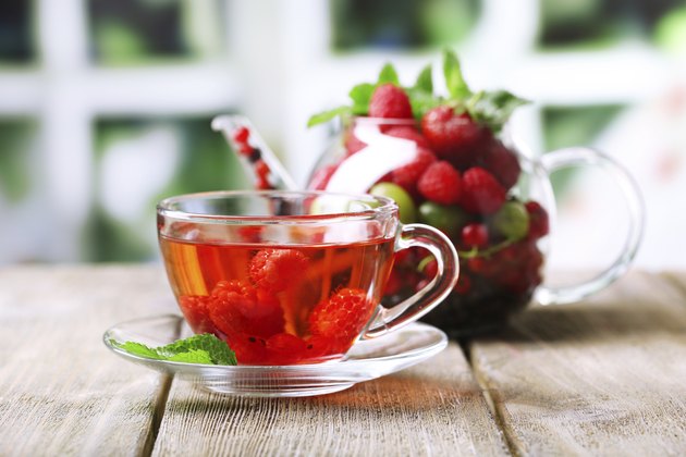 Fruit red tea with wild berries in cup, on table